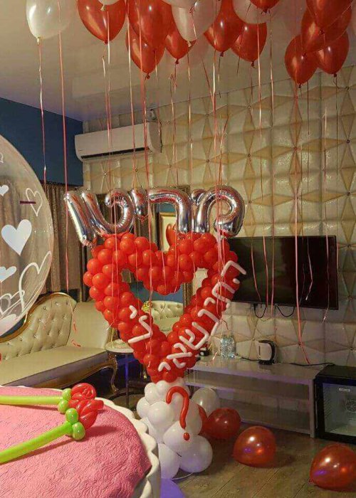 עיצוב בלונים בסלון עם לב אדום והצעת נישואין