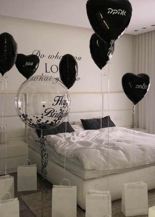 סידור בלונים בחדר לבבות שחורים ובלון כדור פורח